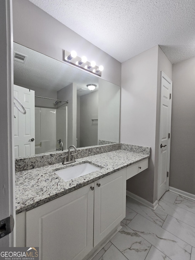 3075 Lakeside Cir, Covington, GA 30016 - full bath featuring vanity, a shower, marble look tile flooring, a textured ceiling, and baseboards