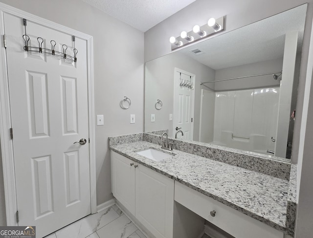 3075 Lakeside Cir, Covington, GA 30016 - bathroom with vanity, a textured ceiling, marble look tile flooring, baseboards, and  shower combination