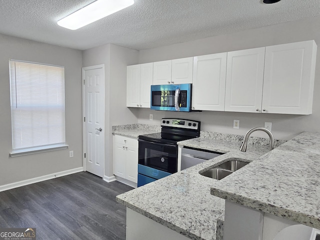 3075 Lakeside Cir, Covington, GA 30016 - kitchen featuring stainless steel appliances, dark wood-style flooring, light stone countertops, white cabinetry, and a textured ceiling