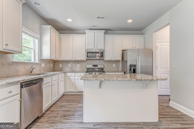 31 Blarneystone Way, Adairsville, GA 30103 - kitchen featuring stainless steel appliances, a sink, a center island, light wood-style floors, and white cabinets