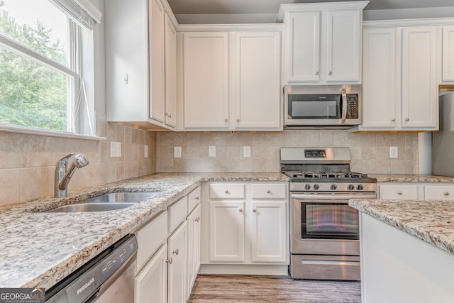 31 Blarneystone Way, Adairsville, GA 30103 - kitchen with stainless steel appliances, a sink, white cabinetry, light wood finished floors, and backsplash