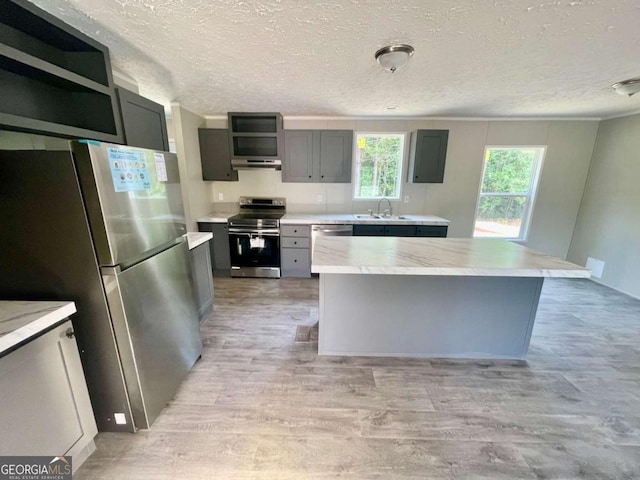429 Avant Rd, Eatonton, GA 31024 - kitchen with stainless steel appliances, a sink, a textured ceiling, open shelves, and light wood-type flooring