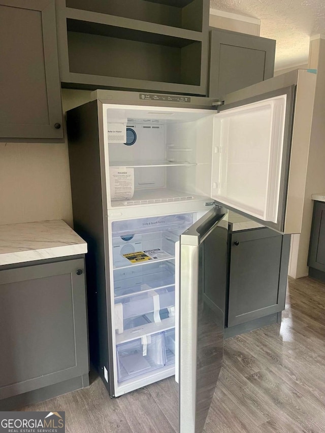 429 Avant Rd, Eatonton, GA 31024 - kitchen featuring freestanding refrigerator, light wood-type flooring, gray cabinets, and light countertops