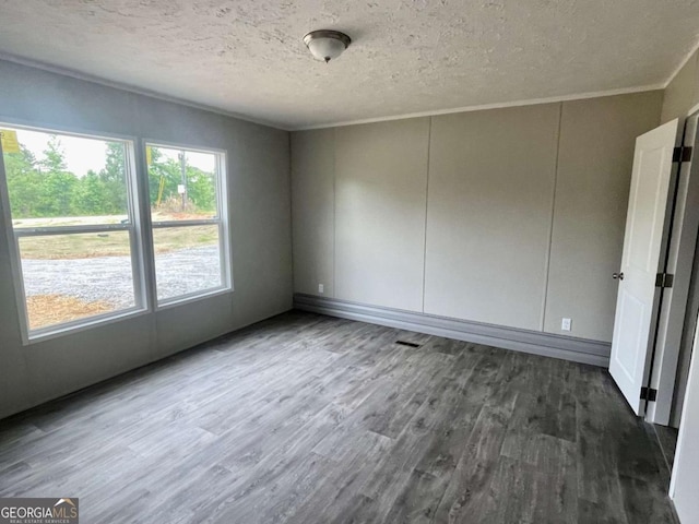 429 Avant Rd, Eatonton, GA 31024 - spare room featuring dark wood-type flooring, a textured ceiling, and crown molding