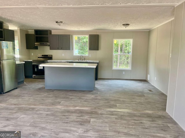 429 Avant Rd, Eatonton, GA 31024 - kitchen featuring appliances with stainless steel finishes, a textured ceiling, under cabinet range hood, a center island, and light countertops