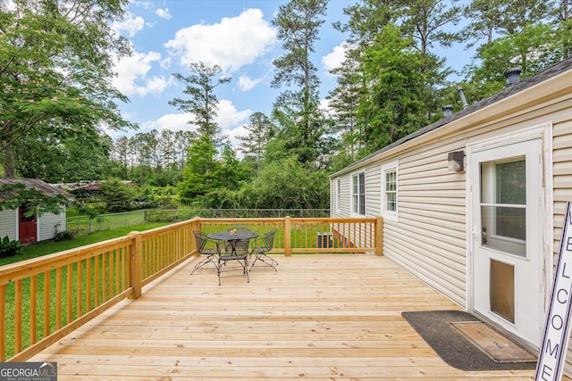 1055 Wrens Hwy, Thomson, GA 30824 - wooden terrace with outdoor dining space and view of wooded area