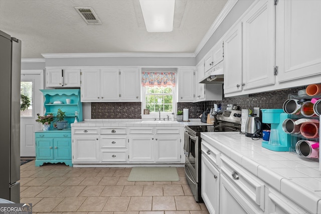1055 Wrens Hwy, Thomson, GA 30824 - kitchen featuring stainless steel appliances, crown molding, tile countertops, white cabinets, and a sink