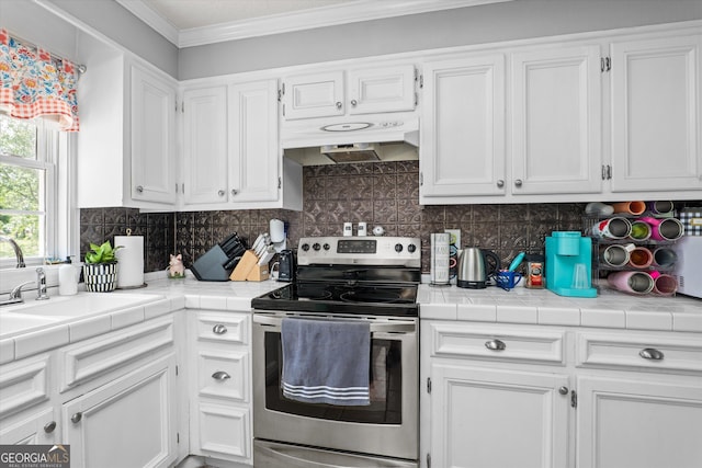 1055 Wrens Hwy, Thomson, GA 30824 - kitchen with stainless steel electric range oven, under cabinet range hood, white cabinets, ornamental molding, and a sink