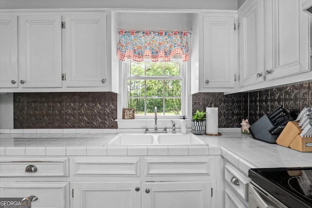 1055 Wrens Hwy, Thomson, GA 30824 - kitchen with a sink, white cabinets, decorative backsplash, and tile counters