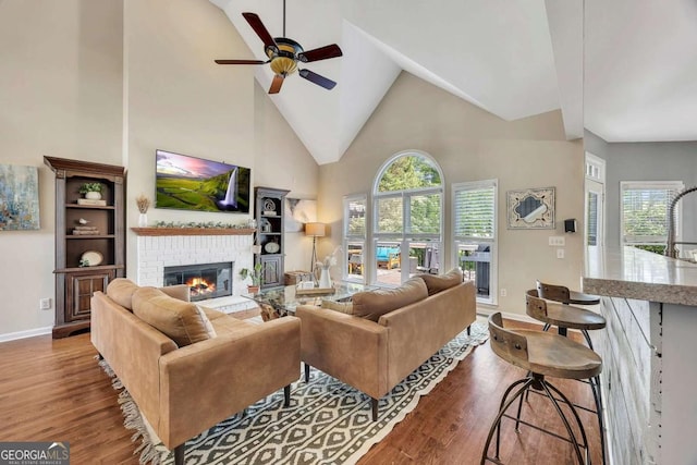 320 Ironhill Trce, Woodstock, GA 30189 - living room with a brick fireplace, high vaulted ceiling, ceiling fan, wood finished floors, and plenty of natural light