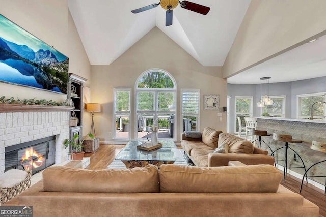 320 Ironhill Trce, Woodstock, GA 30189 - living area with wood finished floors, ceiling fan, a fireplace, baseboards, and high vaulted ceiling