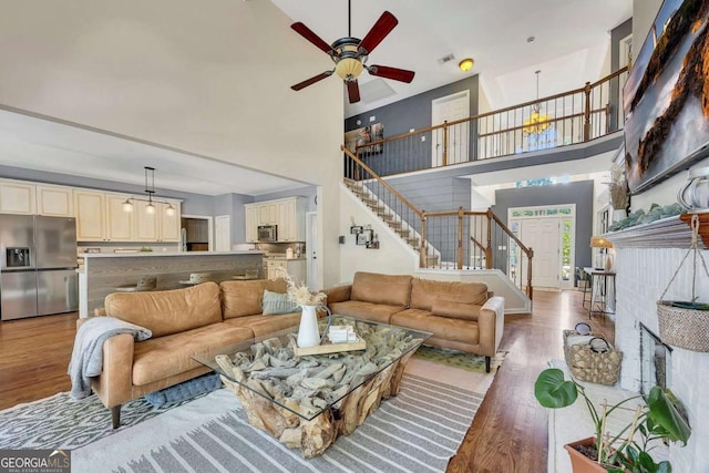 320 Ironhill Trce, Woodstock, GA 30189 - living room featuring stairs, a towering ceiling, light wood finished floors, and a ceiling fan