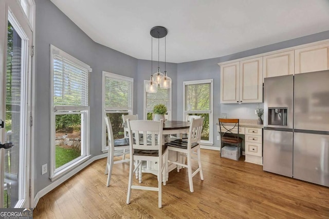 320 Ironhill Trce, Woodstock, GA 30189 - dining area with light wood finished floors, healthy amount of natural light, a chandelier, and baseboards