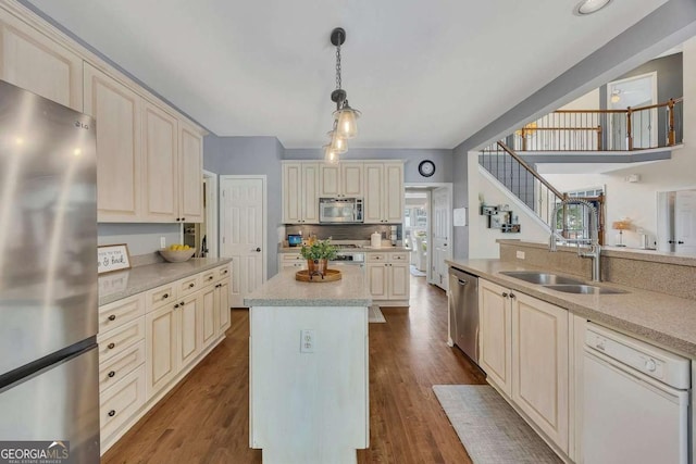 320 Ironhill Trce, Woodstock, GA 30189 - kitchen with appliances with stainless steel finishes, cream cabinets, a sink, decorative light fixtures, and a center island
