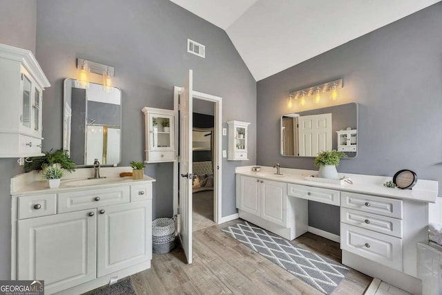 320 Ironhill Trce, Woodstock, GA 30189 - full bath with wood finished floors, high vaulted ceiling, two vanities, and baseboards