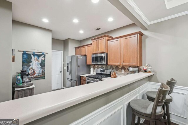 2910 Cross Creek Dr, Cumming, GA 30040 - kitchen featuring stainless steel appliances, backsplash, brown cabinets, recessed lighting, and light countertops
