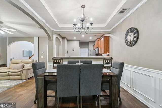 2910 Cross Creek Dr, Cumming, GA 30040 - dining area with arched walkways, dark wood-style floors, a tray ceiling, a chandelier, and a decorative wall