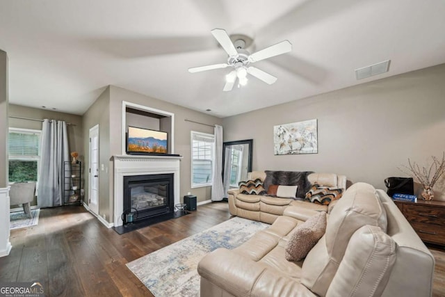 2910 Cross Creek Dr, Cumming, GA 30040 - living area with dark wood-type flooring, a glass covered fireplace, a ceiling fan, and baseboards