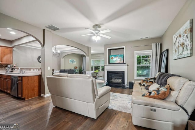 2910 Cross Creek Dr, Cumming, GA 30040 - living area featuring arched walkways, a ceiling fan, a glass covered fireplace, dark wood finished floors, and a chandelier