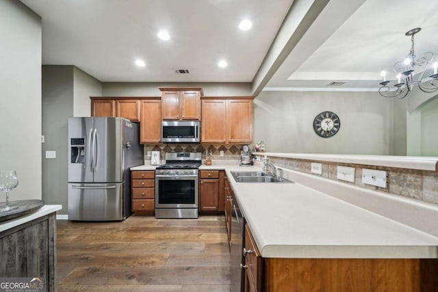 2910 Cross Creek Dr, Cumming, GA 30040 - kitchen featuring stainless steel appliances, a sink, dark wood-style floors, brown cabinetry, and tasteful backsplash