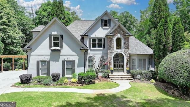 7920 Tintern Trce Unit 298, Duluth, GA 30097 - view of front of home with stucco siding, stone siding, a front lawn, and a shingled roof