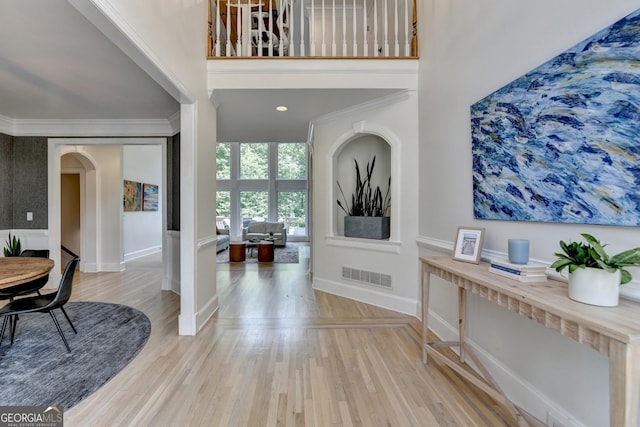 7920 Tintern Trce Unit 298, Duluth, GA 30097 - foyer entrance featuring arched walkways, wood finished floors, crown molding, baseboards, and a high ceiling