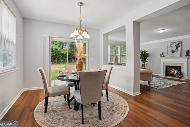 2840 Brookford Ln SW, South Fulton, GA 30331 - dining area featuring a chandelier, dark wood-style floors, a fireplace with flush hearth, and baseboards