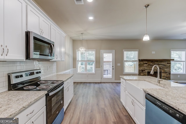 6413 River Plantation Dr, Lula, GA 30554 - kitchen with stainless steel appliances, wood finished floors, backsplash, white cabinetry, and a sink