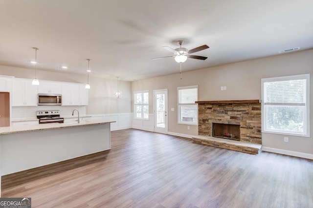 6413 River Plantation Dr, Lula, GA 30554 - unfurnished living room featuring ceiling fan, wood finished floors, a fireplace, a sink, and recessed lighting
