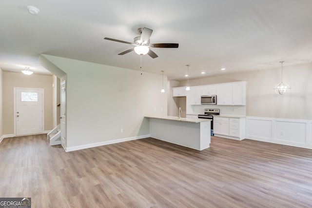 6413 River Plantation Dr, Lula, GA 30554 - unfurnished living room featuring light wood-type flooring, a ceiling fan, stairway, a sink, and baseboards