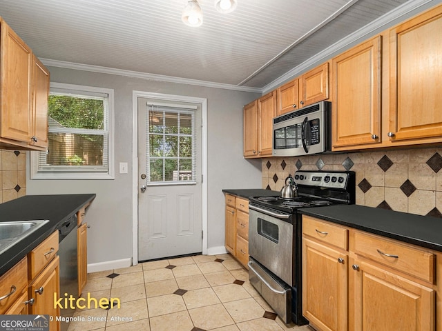 269 Magnolia St, Athens, GA 30606 - kitchen featuring stainless steel appliances, dark countertops, backsplash, crown molding, and light tile patterned floors