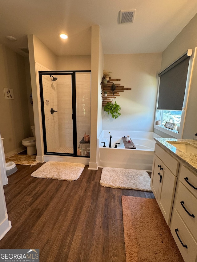 2980 Hd Atha Rd, Covington, GA 30014 - bathroom with a bath, wood finished floors, a stall shower, vanity, and toilet