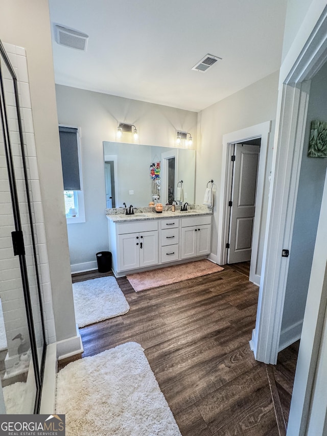 2980 Hd Atha Rd, Covington, GA 30014 - full bathroom with wood finished floors, double vanity, tiled shower, and baseboards