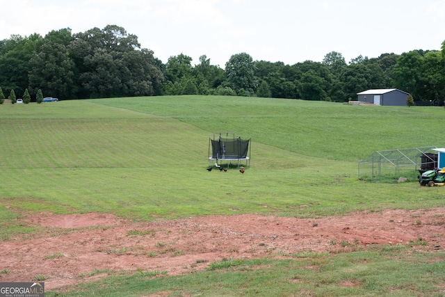 2980 Hd Atha Rd, Covington, GA 30014 - view of property's community with a trampoline, a lawn, and a view of countryside
