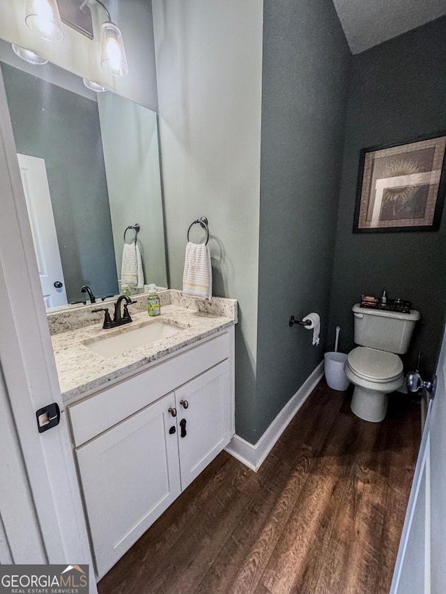 2980 Hd Atha Rd, Covington, GA 30014 - bathroom with wood finished floors, vanity, toilet, and baseboards