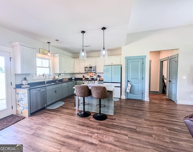 2980 Hd Atha Rd, Covington, GA 30014 - kitchen with appliances with stainless steel finishes, white cabinets, a breakfast bar area, a sink, and dark wood-style floors