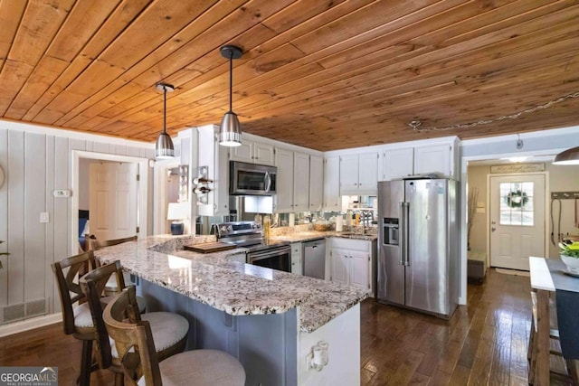 6551 Bermuda Ln, Flowery Branch, GA 30542 - kitchen featuring appliances with stainless steel finishes, wood ceiling, a peninsula, white cabinetry, and light stone countertops