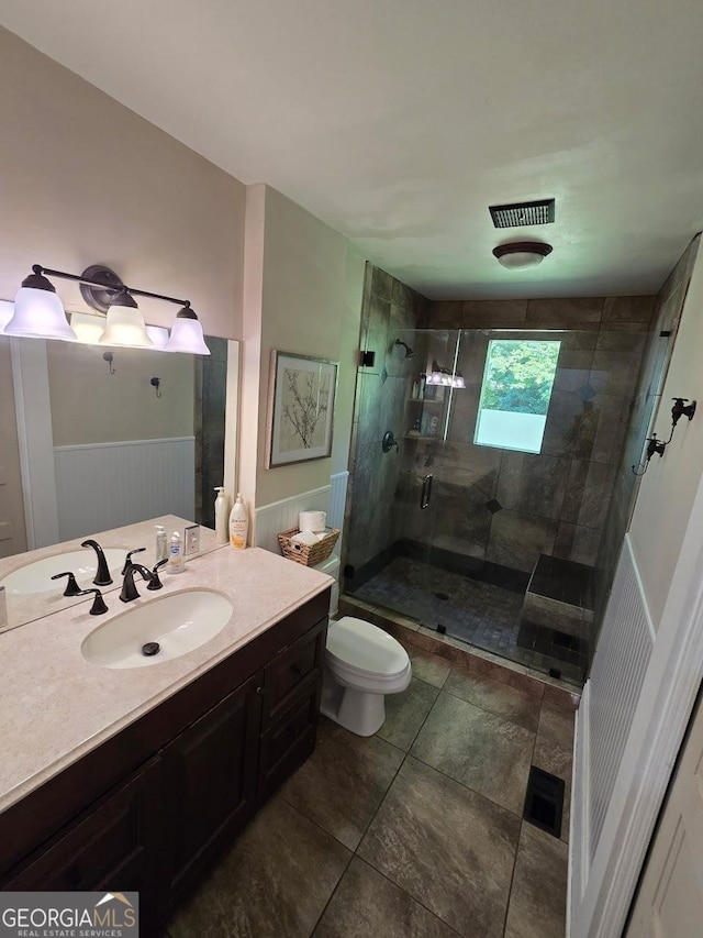 142 Griffin Dr, Carrollton, GA 30117 - bathroom with a stall shower, vanity, a wainscoted wall, and tile patterned flooring