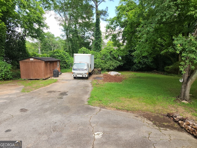 142 Griffin Dr, Carrollton, GA 30117 - view of green lawn featuring a storage shed and asphalt driveway