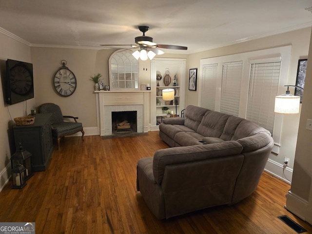 142 Griffin Dr, Carrollton, GA 30117 - living room with crown molding, dark wood finished floors, a ceiling fan, a fireplace, and built in features