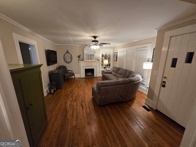 142 Griffin Dr, Carrollton, GA 30117 - living room with dark wood-style flooring, a ceiling fan, a fireplace with flush hearth, and ornamental molding