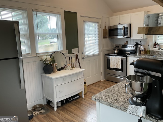 574 Lakeview Dr, Gainesville, GA 30501 - kitchen with appliances with stainless steel finishes, light wood-style floors, white cabinets, lofted ceiling, and light stone countertops