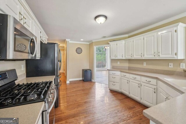 1535 Lake Dow Rd, Mcdonough, GA 30252 - kitchen featuring stainless steel appliances, white cabinetry, crown molding, and light countertops