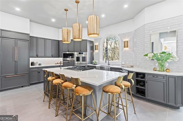 8610 Sentinae Chase Dr, Roswell, GA 30076 - kitchen with stainless steel appliances, backsplash, light countertops, an island with sink, and a breakfast bar
