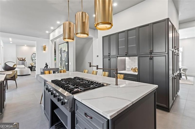 8610 Sentinae Chase Dr, Roswell, GA 30076 - kitchen featuring stove, light stone counters, hanging light fixtures, tasteful backsplash, and gray cabinets