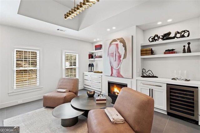 8610 Sentinae Chase Dr, Roswell, GA 30076 - indoor dry bar with wine cooler, a warm lit fireplace, tile patterned flooring, recessed lighting, and built in shelves