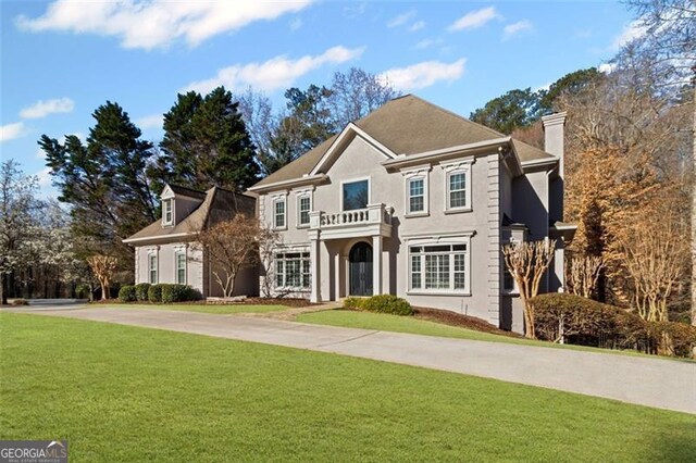 8610 Sentinae Chase Dr, Roswell, GA 30076 - colonial-style house with a balcony, a chimney, a front yard, and stucco siding