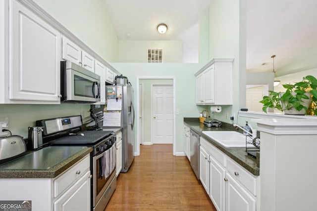198 Lake Cv, Approach, Newnan, GA 30265 - kitchen featuring stainless steel appliances, a sink, dark countertops, and white cabinets