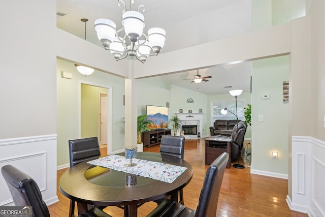 198 Lake Cv, Approach, Newnan, GA 30265 - dining room with a ceiling fan, light wood finished floors, a chandelier, and a fireplace with flush hearth