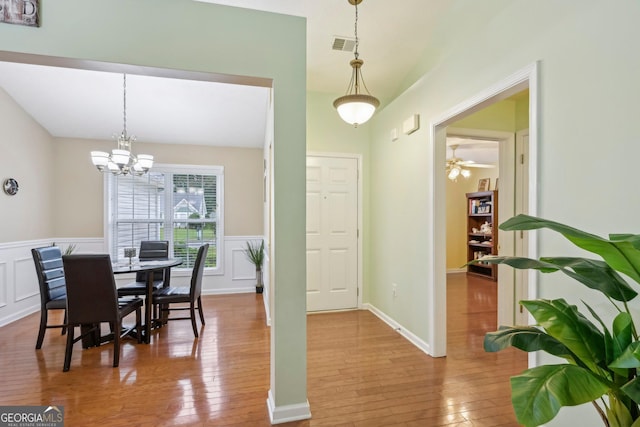 198 Lake Cv, Approach, Newnan, GA 30265 - dining room featuring hardwood / wood-style floors, wainscoting, a chandelier, and a decorative wall